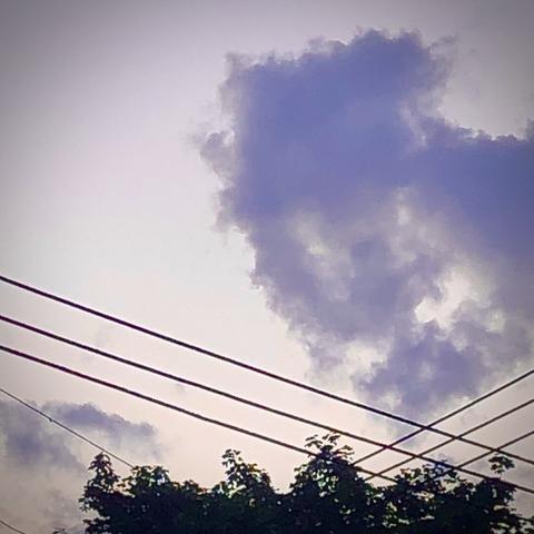 Lavender clouds in a pale sky that could be a profile silhouette or monster with glowing eyes and mouth.