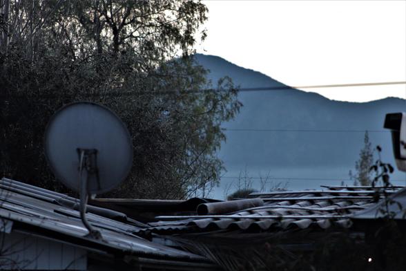 Monte Challay -despejado - detrás de un pimiento boliviano y techo de una casa con su respectiva parabólica