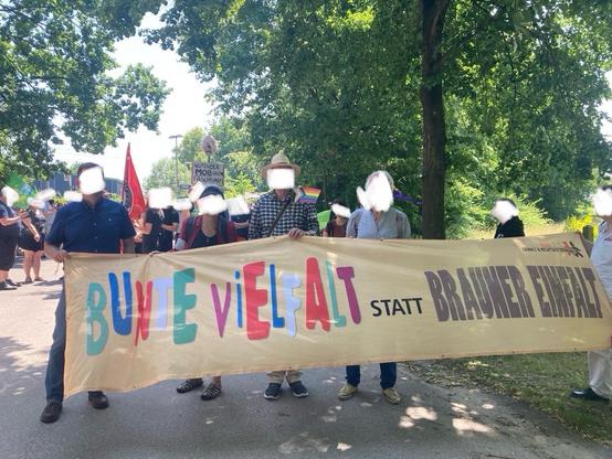 Demonstrierende mit einem in bunten Buchstaben gemalten Banner, Text: Bunte Vielfalt statt brauner Einfalt.