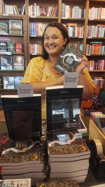 Author Lynsdey Croal posing with her new book, Dark Crescent, in the Edinburgh Bookshop during the book launch