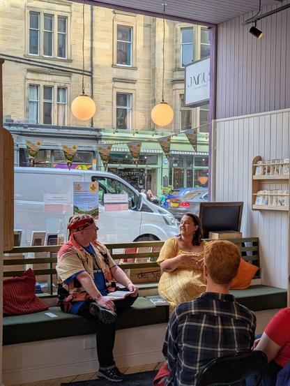 Bookseller Joe chatting with author Lyndsey Croal in front of an audience in the Edinburgh Bookshop, during the launch of her new collection, Dark Crescent