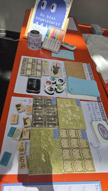A fair stand displaying a collection of stamps. The stamps are used to print postcards. Big stamps of postcard size have different patterns. Additionally small stamps with images of animals, plants, the GPN23 Logo, Fairydust are also available.