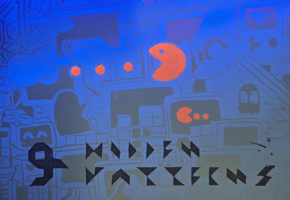 A postcard with a stamped UV-fluorescent pattern and added visible decorations. The main visible decoration is the GPN23 Logo, next to it are highlighted versions of Pacman and its dots. The UV pattern is wild mix of game figures, computers, a "WASD" key set, a cat in a UFO, cute ghosts.