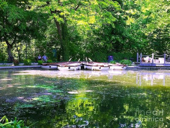 Rowboats rest on a tranquil pond surrounded by lush greenery, reflecting the vibrant green hues of the surrounding trees. A few people can be seen enjoying the serene setting, adding a sense of calmness to the scene.
Captured in Park Maksimir Zagreb.