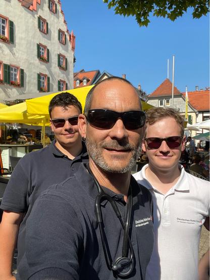 Sefie von drei Sanitätern des DRK-Ortsvereins Nierstein-Oppenheim vor dem Marktplatz Oppenheim während eines Sanitätsdienstes.