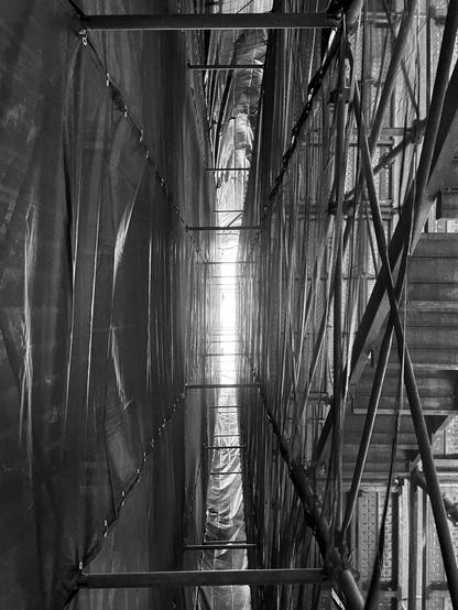 Narrow space between the scaffolding and the building.
