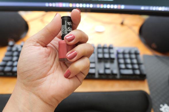 Hand umschließt ein Nagellackfläschen