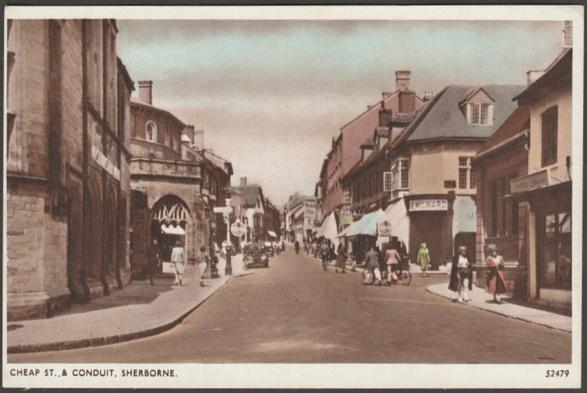 Printed colour postcard showing a view of Cheap Street and the Conduit at Sherborne in Dorset.

Published by E A Sweetman & Son Ltd, Tunbridge Wells, Solograph Series, No 52479, c.1940s.

Postally unused.

Very good condition, with very slight corner bumps.