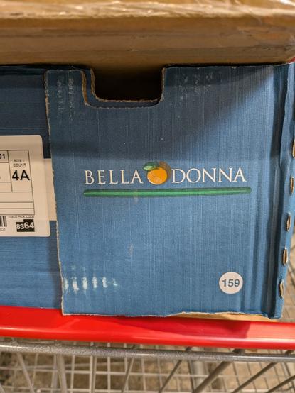 A cardboard box with a picture of a fruit, possibly an orange or apricot, named bella donna.