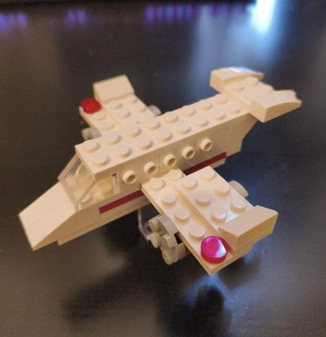 It's a custom ("MOC") lego aeroplane with five passenger windows each side, white with a red stripe, the main body is two dots wide.