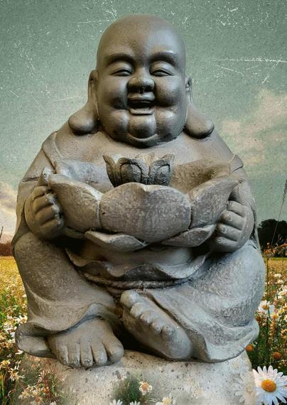 A weathered stone-like sculpture of a seated Buddha with a serene smile, holding a lotus flower in cupped hands. The statue is set against a soft-focus background featuring a field of daisies and a textured, pale green sky.