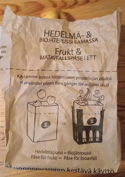 photo of a rectangular paper bag with writing on it and images explaining izs use as a grocery bag first and later as a compost bag