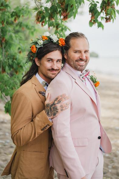 Two beautiful grooms posing on the Beach of Lake Michigan in Milwaukee on their wedding day at Schlitz Audubon Nature Center