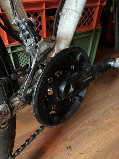 Pedals and crankset with three different sized chainrings. An old front derailleur from Shimano controls the chain position