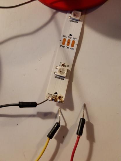 Photo d'un ruban de LEDs où un seul câble est soudé et il ya deux câbles non soudés et des brûlures au niveau des soudures