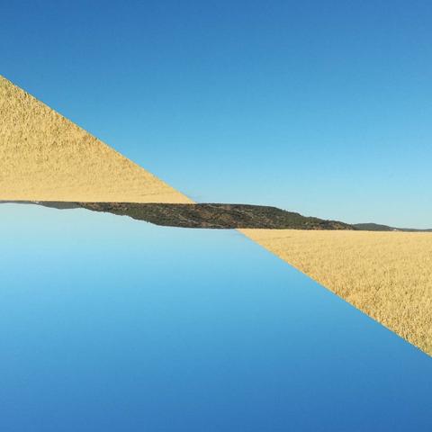 A symmetrical view of a wheat field and blue sky