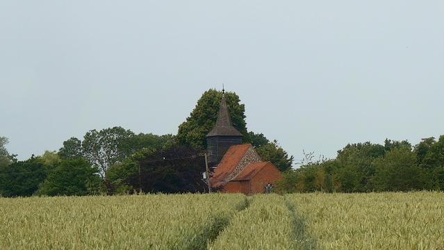 Once the church was located close to the agricultural workers while the village itself lined the old Roman Road nearby. Now the church remains in near silent isolation near the crop fields, but remains in use to this day, its bricks holding steady in changing times. St Giles church at Mountnessing, Essex, England . June 2025.