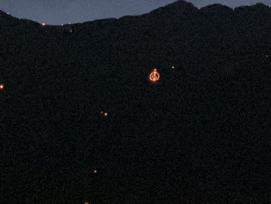 innsbrucks nordkette im dunkeln, mehrere feuer. ein großes feuer in form einer vulva über der höttinger alm.