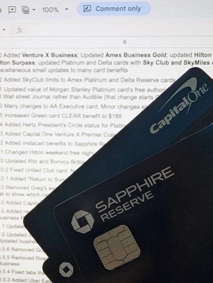 A Chase United Club business card, a Chase Sapphire Reserve card, and a Capital One Venture X card held in front of a copy of the "Which Premium Credit Cards are Keepers?" Google Doc spreadsheet.