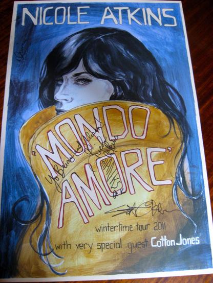 A concert poster for Nicole Atkins, featuring an illustrated portrait of a woman with long hair. The text highlights the title "Mondo Amore," along with details about the "wintertime tour 2011" and the special guest Cotton Jones.