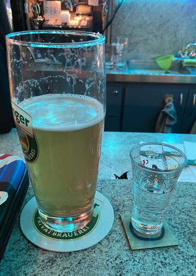Links ein halbvolles Bier, rechts ein halbvoller Schnaps