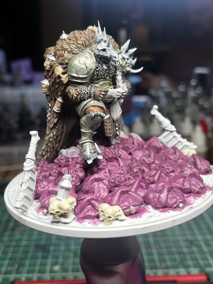 Partially painted miniature.  Man in armor standing on a hoard of dead bodies.