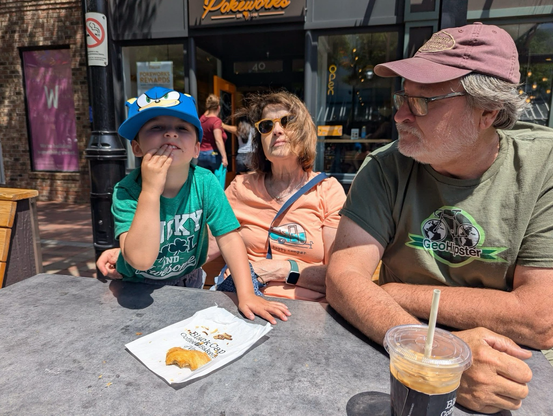 A photograph of Don Meltz, his wife Terry, and grandson Paxton, enjoying a chocolate croissant.