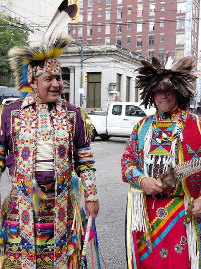 In Vancouver 's downtown east side, two grass dancers share a moment.