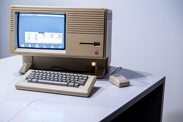 A large beige Apple Lisa computer showing system showing the Lisa office system desktop