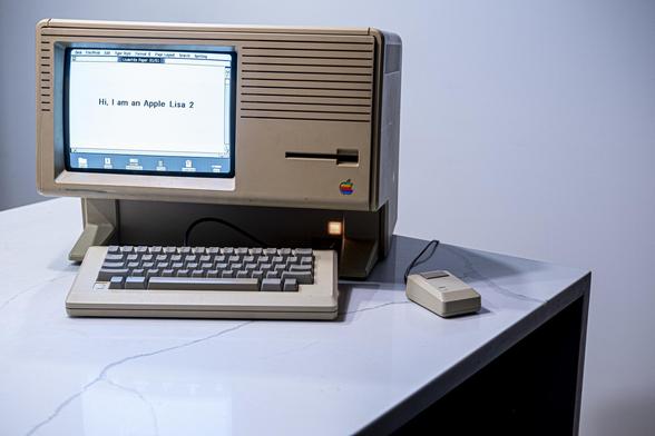 A large beige Apple Lisa computer showing system showing a text editor with text Hi I am an Apple Lisa 2