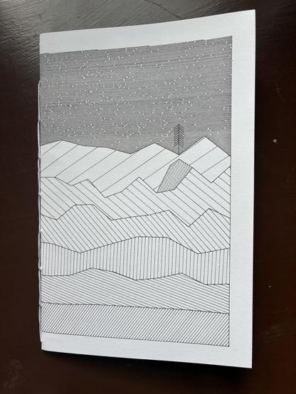 The same drawing from the first image, now folded in half. It is the cover of a notebook.