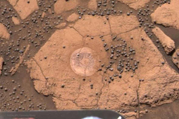 2025 June 22
The image looks down on an orange rock on Mars. On the rock are many nearly spherical smaller rocks. 

A Berry Bowl of Martian Spherules
 * Image Credit: NASA, JPL, Curiosity Rover

Explanation: 
How were these unusual Martian spherules created? Thousands of unusual gray spherules made of iron and rock and dubbed blueberries were found embedded in and surrounding rocks near the landing site of the robot Opportunity rover on Mars in 2004. To help investigate their origin, Opportunity found a surface dubbed the Berry Bowl with an indentation that was rich in the Martian orbs. The Berry Bowl is pictured here, imaged during rover's 48th Martian day. The average size of a Martian blueberry rock is only about 4 millimeters across. By analyzing a circular patch in the rock surface to the left of the densest patch of spherules, Opportunity obtained data showing that the underlying rock has a much different composition than the hematite rich blueberries. This information contributes to the growing consensus that these small, strange, gray orbs were slowly deposited from a bath of dirty water.

Authors & editors: Robert Nemiroff (MTU) & Jerry Bonnell (UMCP)
NASA Official: Amber Straughn Specific rights apply.
NASA Web Privacy, Accessibility, Notices;
A service of: ASD at NASA / GSFC,
NASA Science Activation
& Michigan Tech. U.