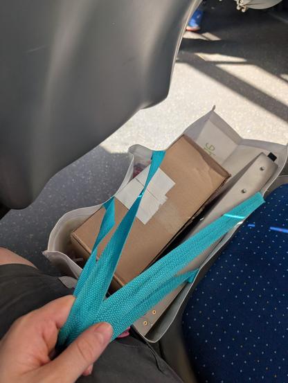 Pappschachtel und Netzwerkswitch in Tüte auf Busboden
