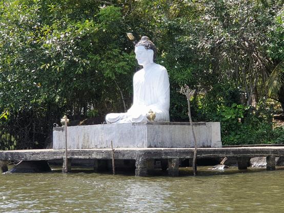 Statue de Bouddha blanche, dans la position du lotus, flottant sur un ponton sur la rivière au Sri Lanka, au sud de Colombo.