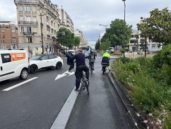 Un groupe de cyclistes arrêtés à une intersection, de dos