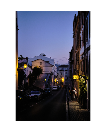 dimly lit alley in lisbon neighborhood under violet blue night sky, two people with delivery bags waiting outside the entrance under the restaurant sign „crispy mafya“