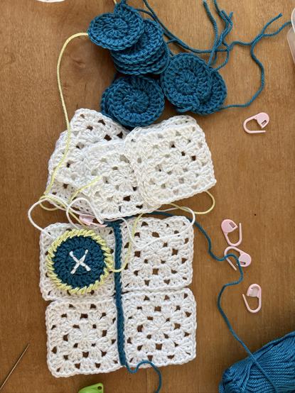 4 witte kleine granny squares aan elkaar gehaakt met petrol garen en stapeltje kleine rondjes