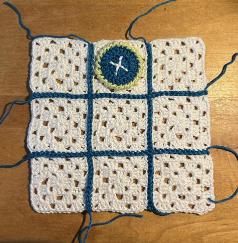 9 kleine witte granny squares tot 3x3 aan elkaar gehaakt met petrol garen