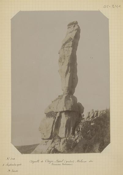 photographie sépia de l'Aiguille de Cayre-Borel (Hautes-Alpes) en 1903. au pied de l'aiguille la silhouette d'un homme
