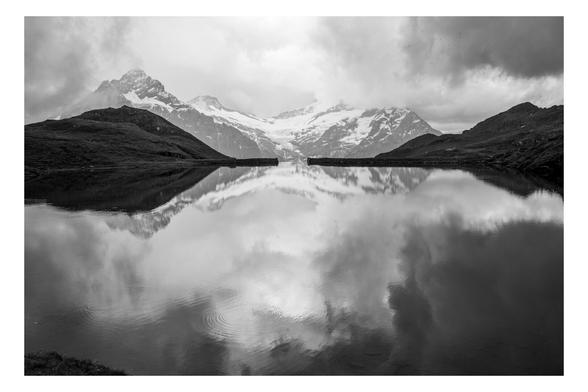 A mountain lake in the Swiss Alps. Dark storm clouds are reflected in the water.