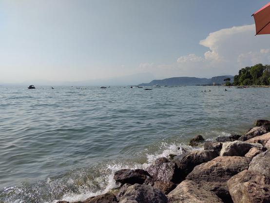Blick aufs Wasser mit brechender Welle im Ufergestein