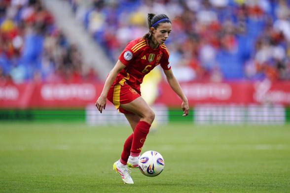 Aitana Bonmatí im Trikot Spaniens, sie nimmt gerade einen Ball mit dem Außenrist an während sie schaut, wo sie als nächstes hinspielen kann.