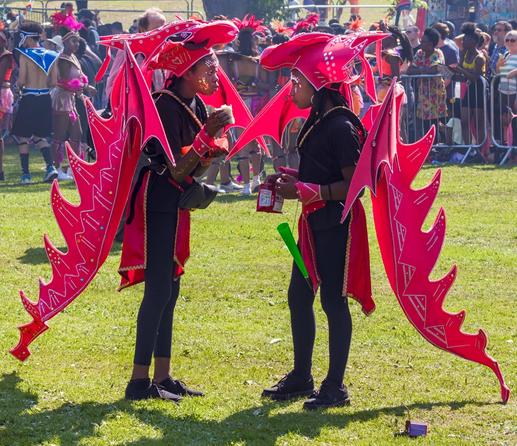 Two children in red dragon costumes stop for lunch during the carnival festivities