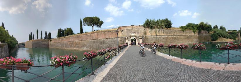 Panorama des Kanals und der Maueranlage von außen. 
Mittig im Panorama die Brücke zum Tor in der Mauer