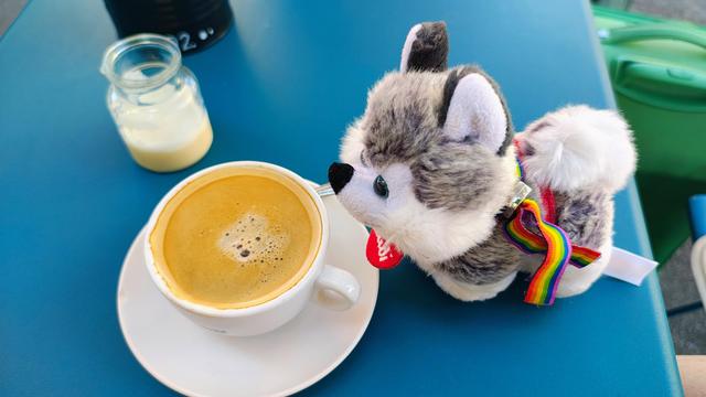 Plüschi Lea steht vor einer Tasse Kaffee