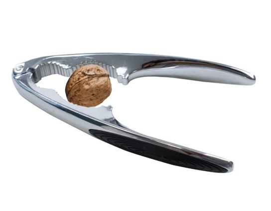 a handheld nutcracker, the type with toothed jaws and a hinge at the far end, there is a walnut in it.