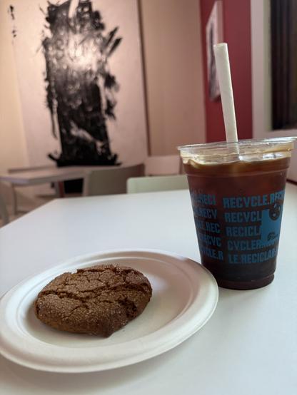 Today’s choice: a ginger molasses cookie and an iced americano. In the background is a painting by a local artist.