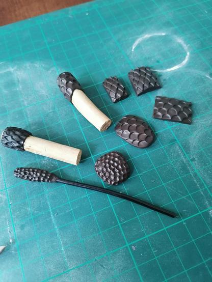 Foto von selbst gemachten schwarzen Texturrollern und Stempeln um Haut und verschiedene Schuppen in Skulpey zu drucken.