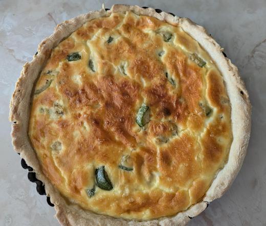Quiche de calabacín (zucchini)/ jamón dorada, recién salida del horno. Se ve el molde de metal en el que está.