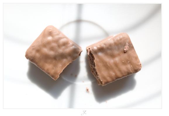 Close-up of a brown, split TimTam chocolate cookie from above. The cookie is lying on a white saucer. The two parts of the cookie build an angle of perhaps 80°. A few crumbs lie in front of the two parts. A blind casts soft, thin shadows above the otherwise white picture. 

AI disclaimer: Using my work, its meta data, written or derived description to create media with or train AI based systems is prohibited.